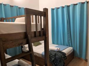 1 Schlafzimmer mit 2 Etagenbetten mit blauen Vorhängen in der Unterkunft Villa Yisbel By Hospedify - Villa con Piscina, jacuzzi, mesa de billas, y cancha de Basketball in Jarabacoa + 48 Fotos