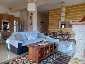 a living room with a blue couch and a table at studio Nick in Kalavrita