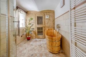a bathroom with a wooden tub and a barrel at Exkluzivní chalupa Podještědka s grilem a saunou in Světlá pod Ještědem