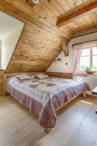 ein Schlafzimmer mit einem Bett in einer Holzdecke in der Unterkunft Exkluzivní chalupa Podještědka s grilem a saunou in Světlá pod Ještědem