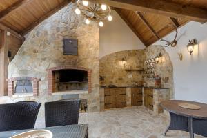 a stone fireplace in a dining room with a table and chairs at Exkluzivní chalupa Podještědka s grilem a saunou in Světlá pod Ještědem