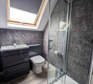 a bathroom with a toilet and a glass shower at Cocali Cottage - Stunning, Spacious property close to Deal Beach ! in Walmer