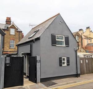 a gray house with a black fence on a street at Cocali Cottage - Stunning, Spacious property close to Deal Beach ! in Walmer