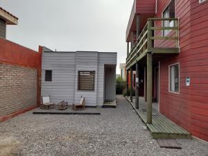 ein winziges Haus zwischen zwei Gebäuden gezeigt wird in der Unterkunft Cabanas Viento Sur. Los Vilos in Los Vilos