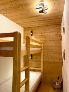 a room with two bunk beds in a cabin at Appartement 2 chambres vue pistes, parking privatif in Les Orres