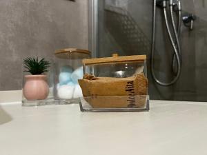 a glass container sitting on top of a bathroom counter at Maison del Ducato Cavour 37 in Parma