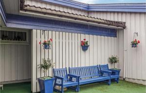 two blue benches sitting next to a building with potted plants at Cozy Apartment In Agdenes With House A Mountain View in Selva