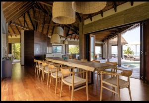 Villa Malolo Levu في مالولو: غرفة طعام مع طاولة وكراسي خشبية كبيرة