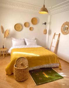 1 dormitorio con 1 cama con colcha amarilla en Caban Surf Tamraght, en Tamraght Ouzdar