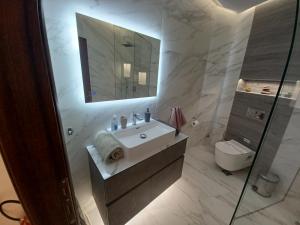 a bathroom with a sink and a mirror and a toilet at Top View Apartment in Katerini