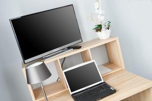 telewizor i laptop na drewnianej półce w obiekcie Komm' In Hotel w mieście Mechernich