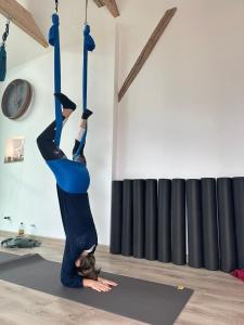 een vrouw die een handstand doet op een yogamat bij Les pieds dans l'eau SWEET HOME in Corné