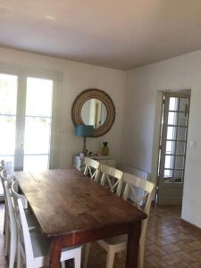 濱海皮里亞克的住宿－Maison familiale 8 personnes，餐桌、白色椅子和镜子