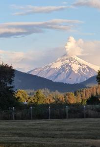 una montaña cubierta de nieve en medio de un campo en Cabañas Rukapillán Región de la Araucanía, en Villarrica