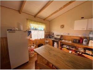 a kitchen with a refrigerator and a table in it at Cabañas Rukapillán Región de la Araucanía in Villarrica