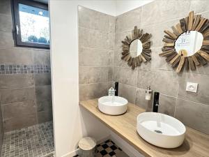 een badkamer met een wastafel en 2 spiegels op een aanrecht bij Les pieds dans l'eau SWEET HOME in Corné