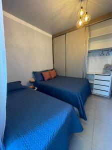 ペーニャにあるBETEL Hospedagemのブルーシーツ付きの客室内のベッド2台