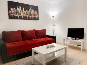 a living room with a red couch and a tv at Cherry Apartment Arena in Belgrade
