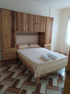 Schlafzimmer mit einem großen Bett mit einem Kopfteil aus Holz in der Unterkunft Departamento Crucita in Crucita