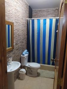 ein Bad mit einem WC, einem Waschbecken und einer Dusche in der Unterkunft Departamento Crucita in Crucita
