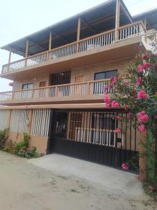 ein Gebäude mit einem Balkon mit rosa Blumen davor in der Unterkunft Departamento Crucita in Crucita