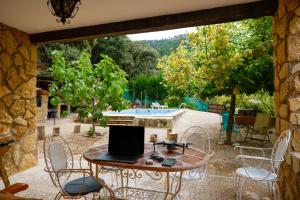 un patio con mesa, sillas y piscina en CAZORLA, CASA RURAL LA GUINDALERA en Cazorla
