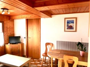 a living room with a wooden table and chairs at LACHAT appartement en chalet typique in Le Grand-Bornand