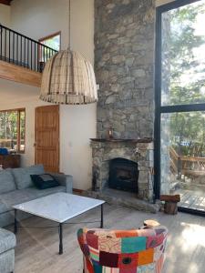 sala de estar con sofá y chimenea de piedra en Zorro Azul - Corazón de la Isla - Tierra del Fuego en Tolhuin