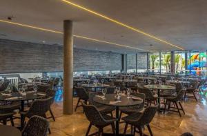 a restaurant with tables and chairs in a building at Salinas Premium Resort in Salinópolis