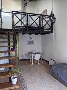 Habitación con cama, mesa y escalera. en Loft c/cochera en la mejor zona de Mendoza - Sol de los Andes en Mendoza