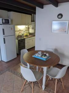 cocina con mesa, sillas y nevera en Loft c/cochera en la mejor zona de Mendoza - Sol de los Andes en Mendoza