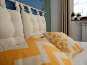 een slaapkamer met een wit bed met kussens erop bij Mind Tiny Home in Rho