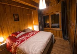 1 dormitorio con 1 cama en una habitación de madera en La Ferme des 3 lacs, en Xonrupt-Longemer