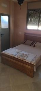 1 cama grande en un dormitorio con ventana en Appart Adoar Tamrakht Taghazout Agadir, en Agadir