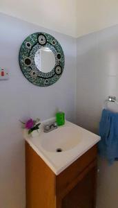 La salle de bains est pourvue d'un lavabo et d'un miroir mural. dans l'établissement StarFish Apartment, à Port Elizabeth