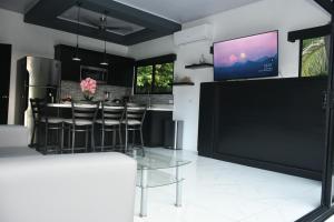 cocina con barra y TV en la pared en Casa Proa en Uvita