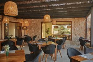 una sala da pranzo con tavoli e sedie in legno di Hotel Rural Es Riquers a Porreres