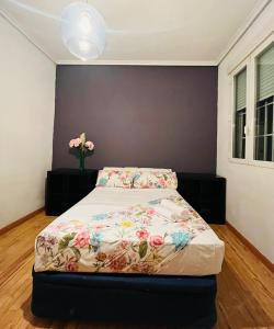 Un dormitorio con una cama con flores. en Piso san Marcos madrid, en Madrid