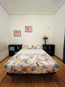 1 dormitorio con 1 cama con colcha de flores en Piso san Marcos madrid, en Madrid
