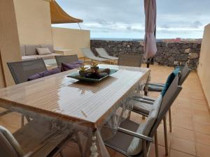 - une table à manger avec des chaises et une table avec un bol de fruits dans l'établissement Relax and Quiet Apartment for remote working, with wonderful sea views in Poris de Abona, Tenerife - Canary Islands, à Poris de Abona