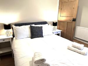 ein Schlafzimmer mit einem großen weißen Bett mit zwei Lampen in der Unterkunft The Ivanhoe Apartment in Rothley