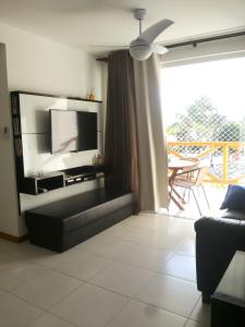 ein Wohnzimmer mit Couch und Flachbildfernseher in der Unterkunft Paraíso dos Corais in Guarajuba