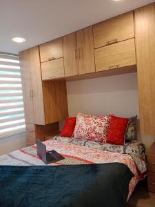 1 dormitorio con 1 cama con ordenador portátil en Amoblado Norte en Bogota, en Bogotá