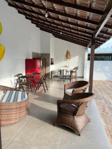- un salon avec des chaises en osier et une table dans l'établissement Casa com piscina Praia dos Molhes, à Torres