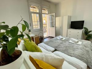 - une chambre avec un lit et une plante en pot dans l'établissement Studio27 - Apartment with balcony at the Buda castle, à Budapest