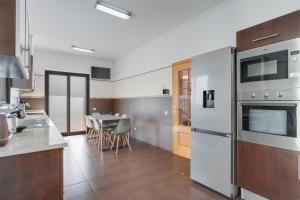 uma cozinha com utensílios de aço inoxidável e uma mesa em Casa Amarela no Funchal
