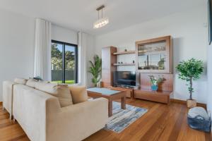 uma sala de estar com um sofá e uma televisão em Casa Amarela em Funchal
