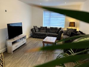 ein Wohnzimmer mit Sofas und einem Flachbild-TV in der Unterkunft Home in Barrow-Upon-Soar in Barrow upon Soar