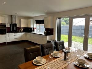 a kitchen with a wooden table with chairs and a dining room at Home in Barrow-Upon-Soar in Barrow upon Soar