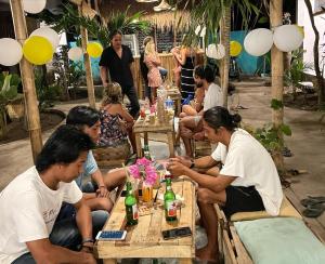 a group of people sitting at a table with drinks at Mango Tree House in Gili Trawangan